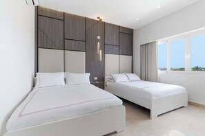 Een hotelkamer met twee bedden, een modern design en een groot raam met uitzicht.