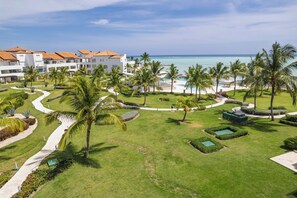 A resort with a pool area, palm trees, and a view of the ocean. - Luxury Beachfront Penthouse Punta Palmera Cap Cana (Punta Cana)