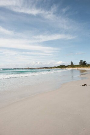 A beach with a clear sky and calm sea.