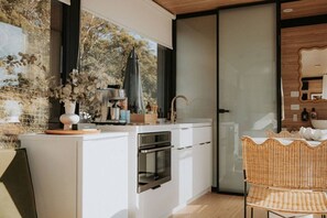 A modern kitchen with a built-in oven, a coffee machine, and a sink. - Casa Collection Bicheno ~ The Bambino (Bicheno)