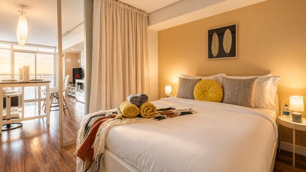 A hotel room with a bed, a desk, and a chair. - Waterfront Grand Escape (Toronto)