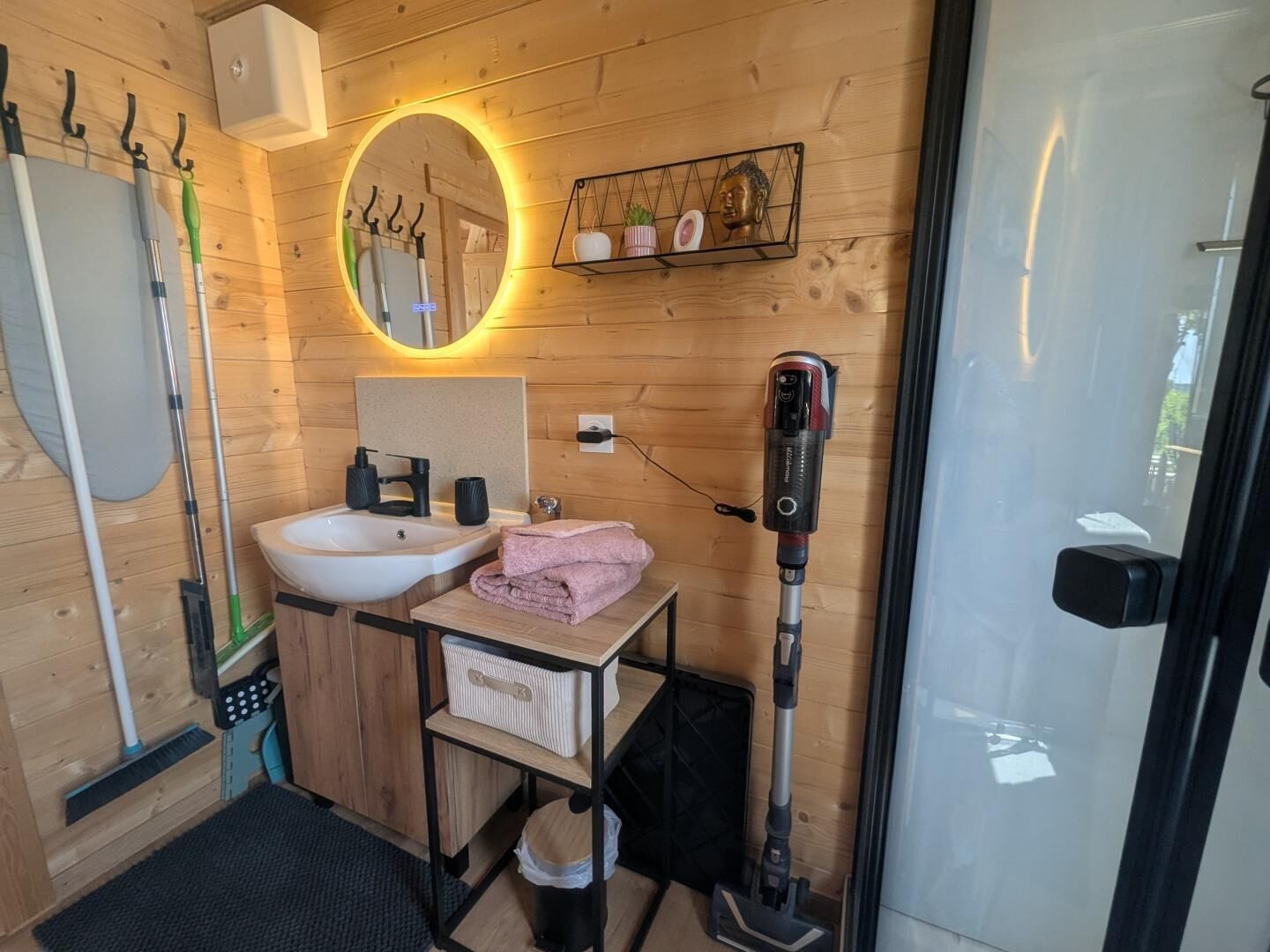 Een kleine badkamer met een wastafel, spiegel en handdoekhouder.