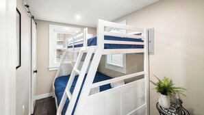 A bunk bed with a ladder, a small table with a plant, and a window with blinds. - Cabin 42 at the Historic Sandy Point Resort W/ Boat Slip and Onsite Boat Ramp (Alton)