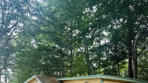 Ein Bungalow mit umzäunter Veranda, einem Schild mit der Nummer 46 und einer kleinen angebauten Garage.