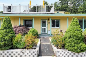 A two-story building with a balcony, a front door, and a small porch area. - Cabin 16 at Historic Sandy Point Resort W/ Boat Slip and onsite boat ramp (Alton)