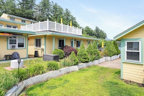 A two-story motel with a balcony, a covered outdoor seating area, and a well-maintained garden. - Cabin 16 at Historic Sandy Point Resort W/ Boat Slip and onsite boat ramp (Alton)