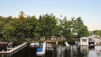 A waterfront property with docked boats, a small dock, and a row of cabins.