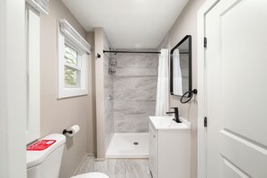 A bathroom with a toilet, a shower, and a sink. - Cabin 60 at Historic Sandy Point Resort W/ Boat Slip and Onsite Boat Ramp (Alton)