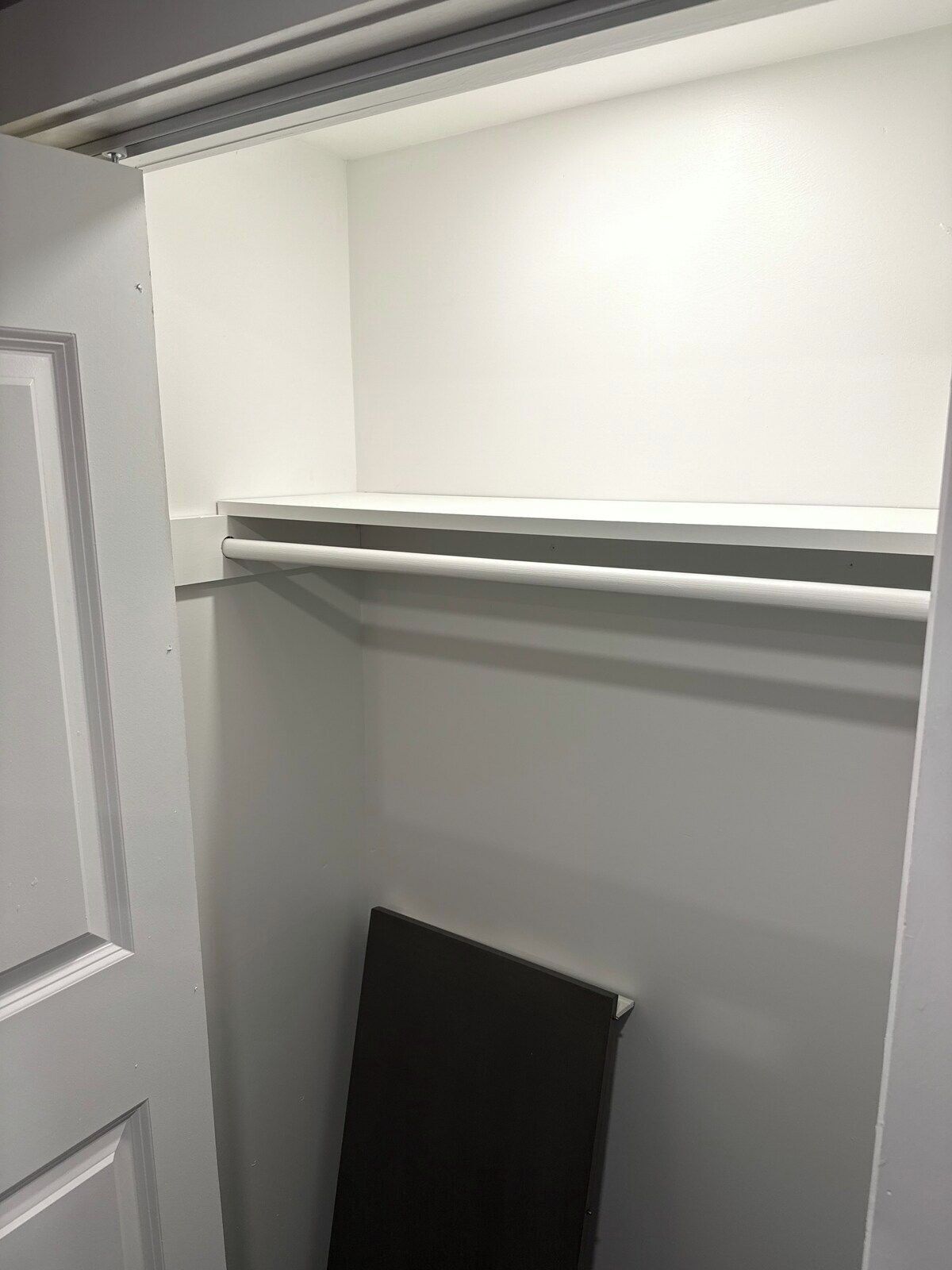 A room with a white door, a black door, and a white wall.
