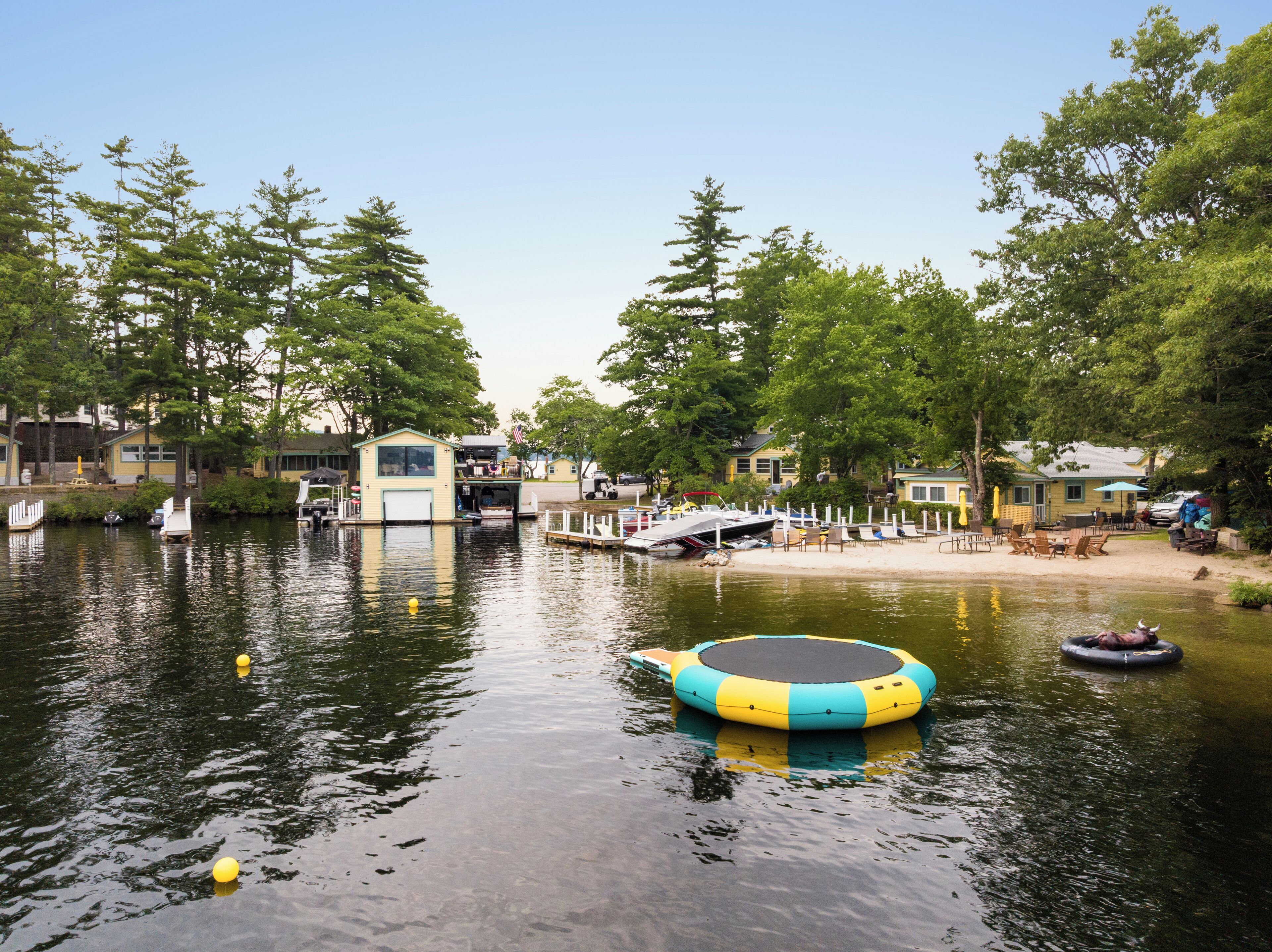 A lakeside area with floating docks, a small house, and a boat.