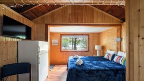 A room with a bed, a desk, a chair, a window, and a door. - Cabin 47 at Historic Sandy Point Resort W/ Boat Slip And Onsite Boat ramp (Alton)