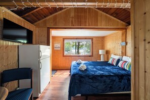 Ein Zimmer mit Bett, Schreibtisch, Stuhl, Fenster und Tür.