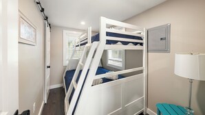 A bunk bed room with a window, a door, and a lamp. - Cabin 48 at Historic Sandy Point Resort W/ Boat Slip and Onsite Boat Ramp (Alton)