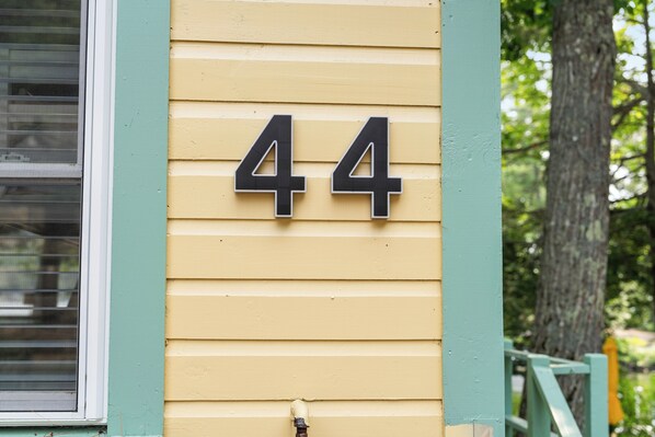 A house number 44 on a yellow siding wall. - Cabin 44 at Historic Sandy Point Resort W/ Boat Slip and Onsite Boat Ramp (Alton)
