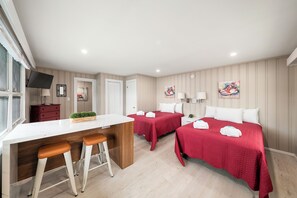A hotel room with a kitchenette, two beds, a TV, and artwork on the walls. - Cabin 31 at Historic Sandy Point Resort W/ Boat Slip and Onsite Boat Ramp (Alton)