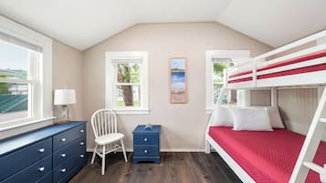 Een slaapkamer met een stapelbed, een bureau, een stoel en een kledingkast.