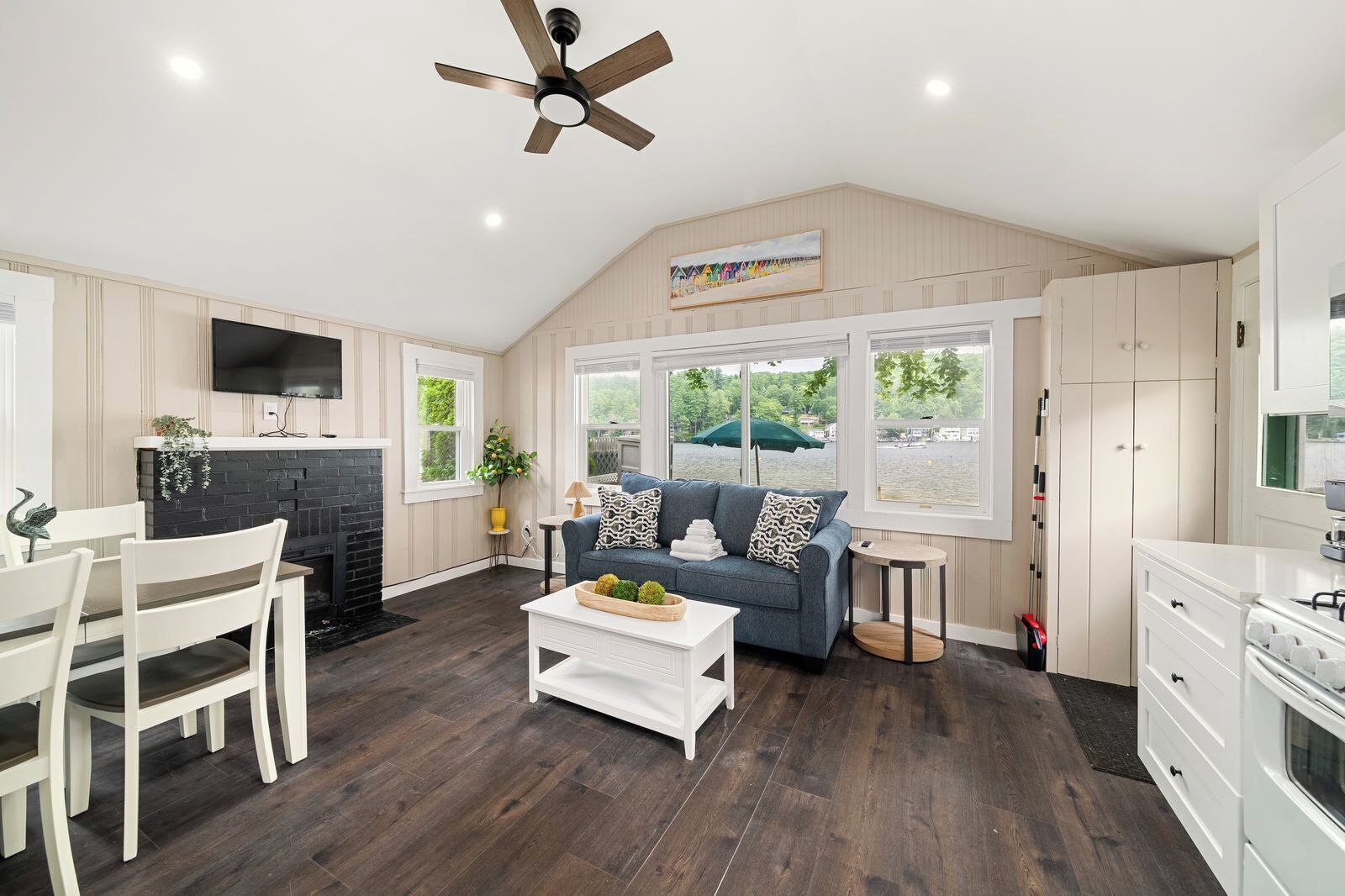 A spacious living room with a fireplace, a sofa, a coffee table, and a television.