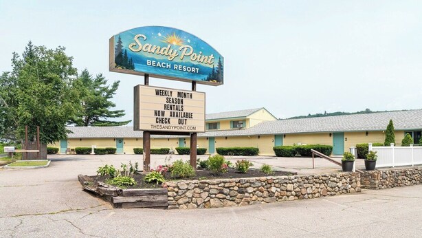 A beach resort sign with a weekly rental availability notice.