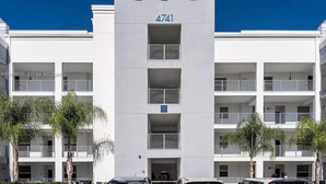 A multi-story building with a flat facade, numbered 4741, featuring balconies and a central entrance. - Storey Lake: Cozy 2BR Near Disney (Kissimmee)