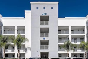 A multi-story building with a flat facade, numbered 4741, featuring balconies and a central entrance.
