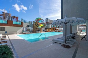A swimming pool with lounge chairs and a large sculpture. - Highrise Condo & Amenities for 2 people (Miami)