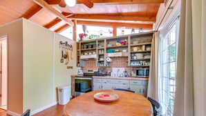 A kitchen with wooden cabinets, a dining table, and a view of the outdoors. - Waterfront Nolin Lake Retreat: Lake Views (Ollie)