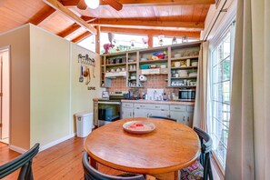 A kitchen with wooden cabinets, a dining table, and a view of the outdoors. - Waterfront Nolin Lake Retreat: Lake Views (Ollie)