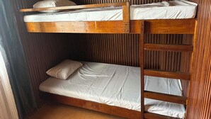 A bunk bed with a wooden frame and white bedding.