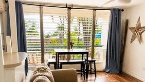 Una sala de estar con un sofá, una mesita de vidrio y un comedor con una mesa y sillas.