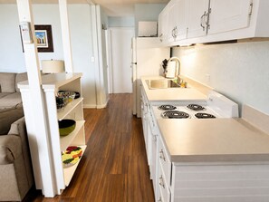 A modern kitchen with white cabinets, a built-in oven, and a stainless steel sink. - Make Memories in Paradise at Long Reef (Christiansted)
