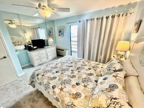 A bedroom with a bed, dresser, television, and curtains. - Guest House 207 - Walk to Garden City Beach (Garden City)