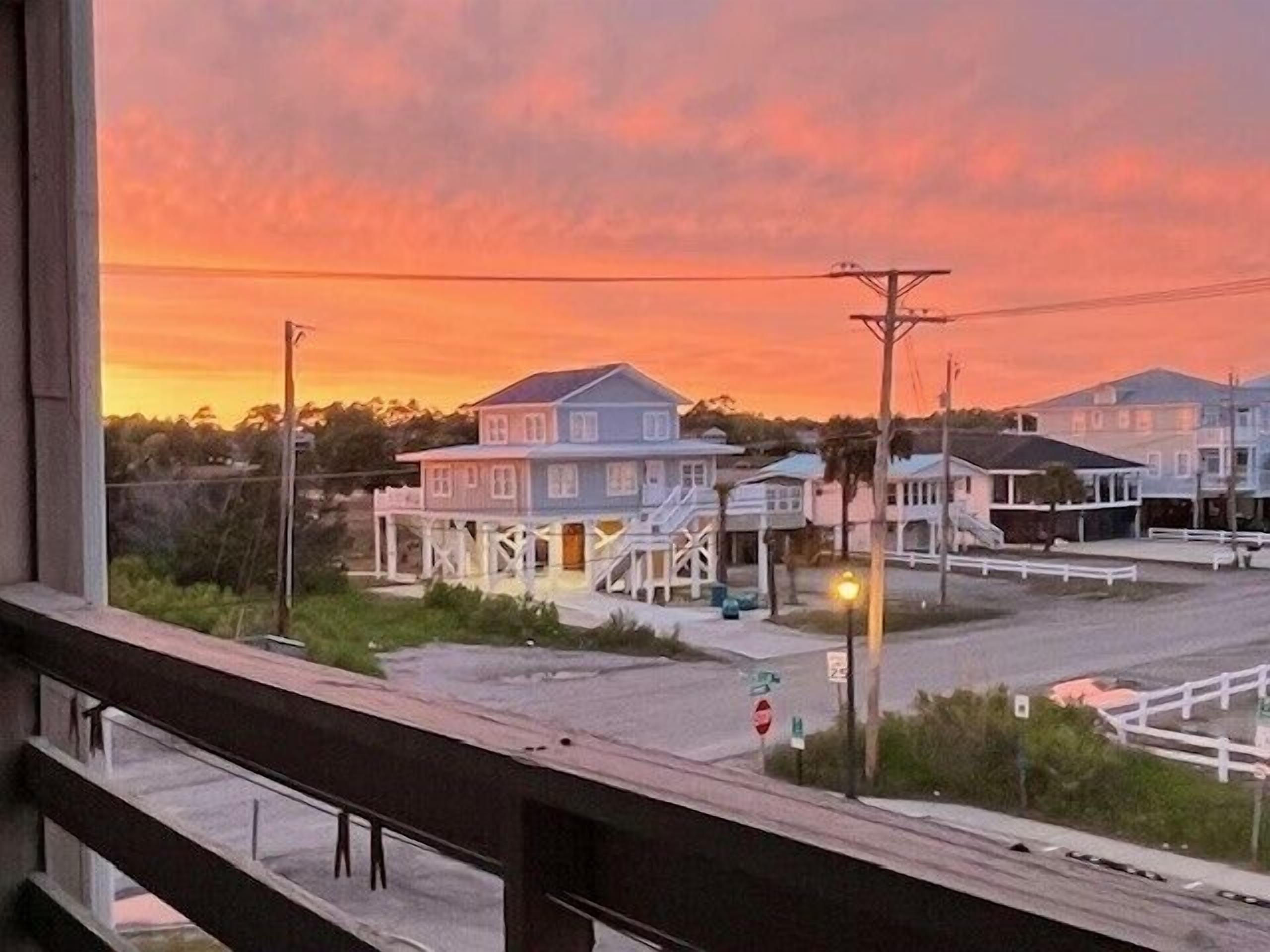 A coastal view with a row of houses during sunset.