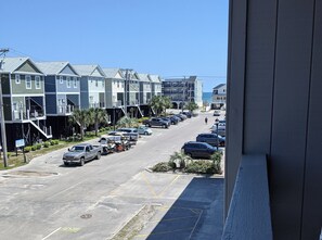 A street view with multi-story buildings, parked cars, and a clear sky. - Guest House 207 - Walk to Garden City Beach (Garden City)