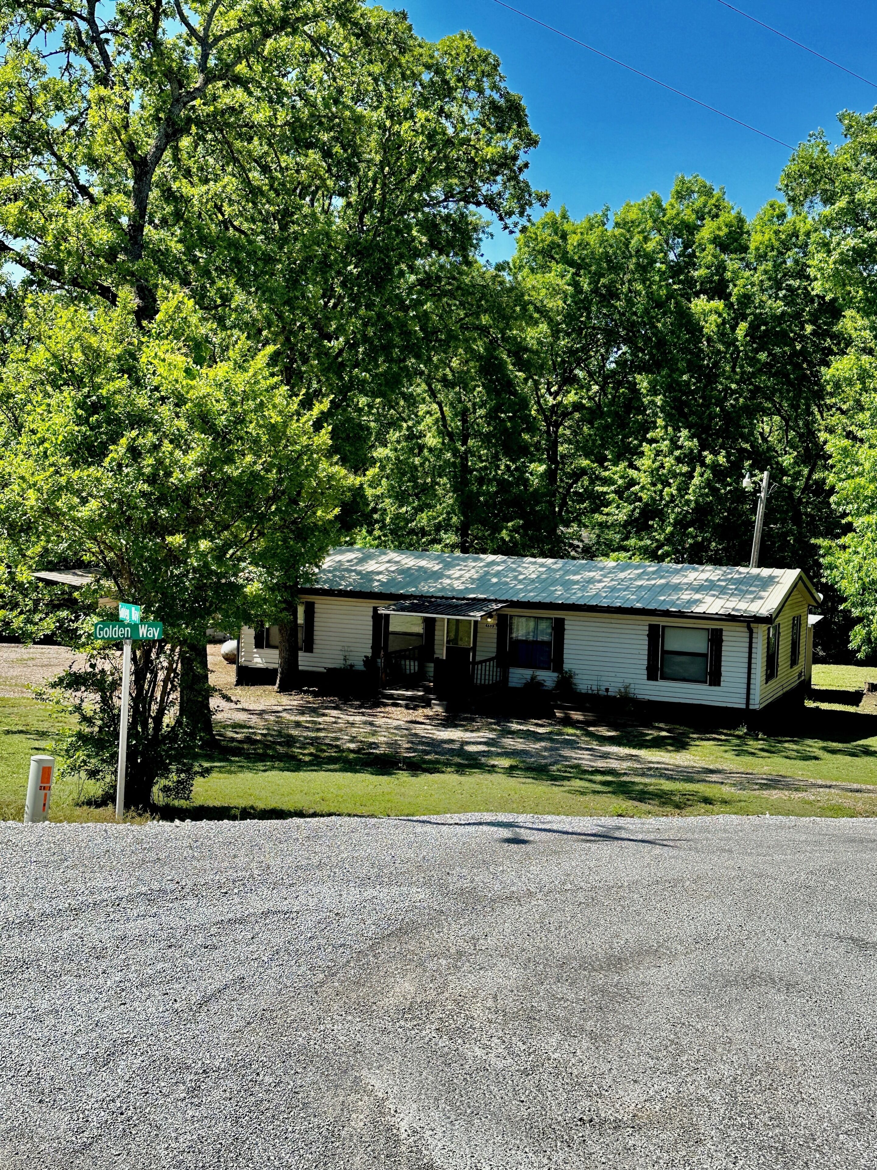 A single-story house with a sloped roof, a front porch, and a small front yard.