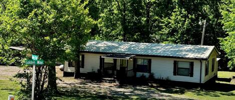 A single-story house with a sloped roof, a front porch, and a small front yard.