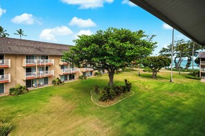 Ein Hotel mit einem zweistöckigen Gebäude, Außenbestuhlung und einem Baum im Innenhof.
