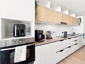 A modern kitchen with a coffee maker, a kettle, and a knife block on the counter. - Oceana Suites Playa Serena (Coquimbo)