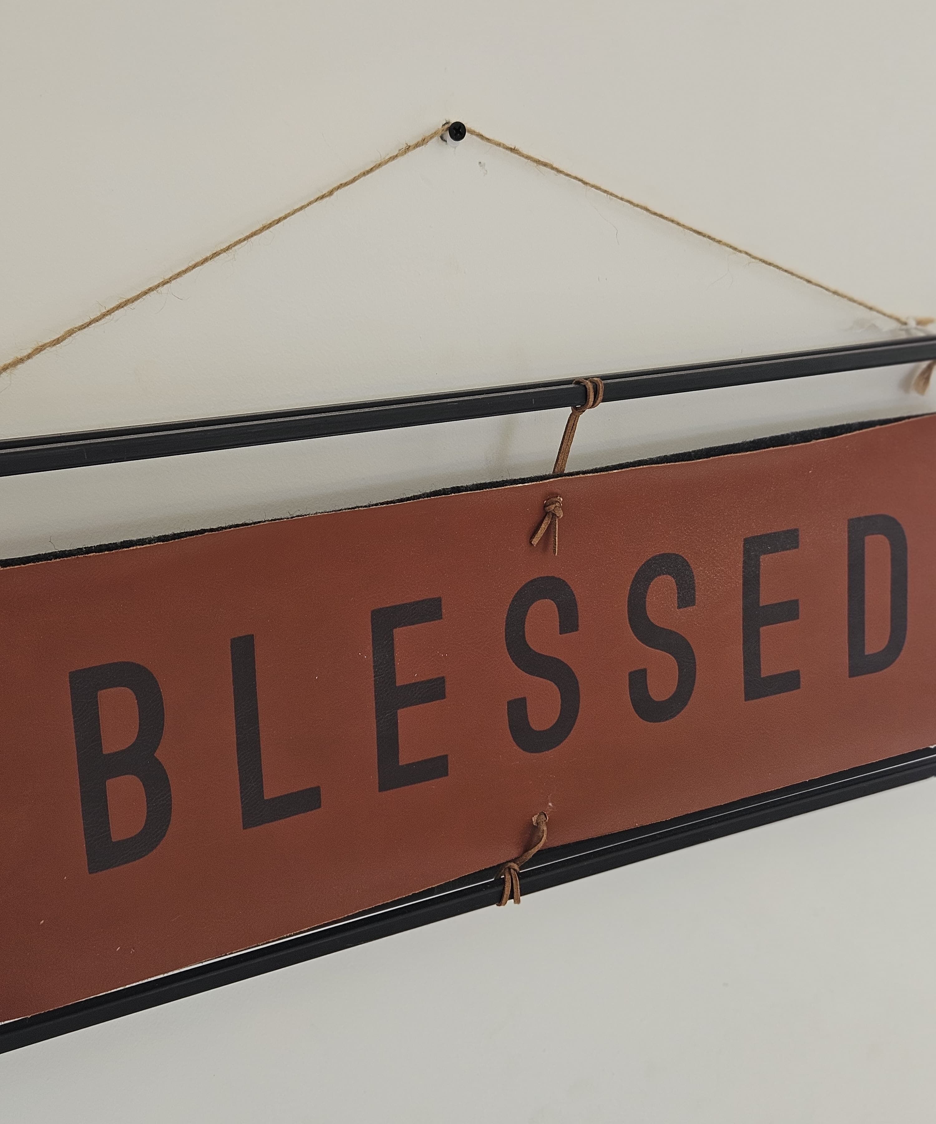 Un letrero con la palabra 'BLESSED' colgada en una pared.