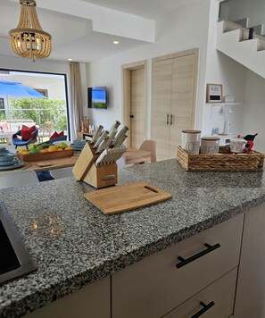 A modern kitchen with granite countertops, a knife block, a cutting board, and a coffee and sugar container. - 2-bedroom townhome in peaceful Punta Cana with AC comfort (Punta Cana)