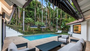 Ein Poolbereich mit Pool, Liegestühlen und einem kleinen Tisch.