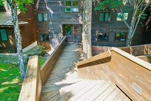 A wooden deck leading to a building with multiple windows and a door. - Come Stay, Relax and Explore B8 (Killington)