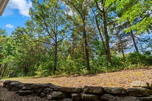 A forested area with a stone wall and a clear sky. - Relax at French Quarter | 2BR Condo with Balcony (Branson)