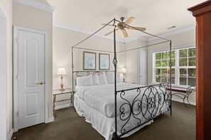 A four-poster bed with a ceiling fan, a window with blinds, and a door. - 2 King Condo | Minutes to Branson Shows & Dining (Branson)