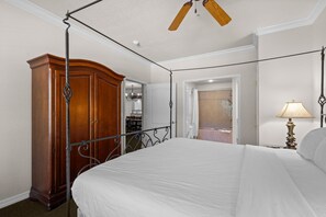 A bedroom with a four-poster bed, a wooden wardrobe, and a ceiling fan. - Near Highway 76 | Spacious 2BR Resort Condo (Branson)