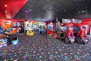 Ein Spielsalon mit verschiedenen Spielautomaten und einem Teppich mit Sternenmuster.