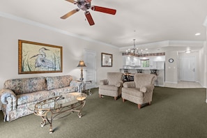 A living room with a sofa, armchairs, a coffee table, a ceiling fan, and a painting. - 2BR Condo Just Off the Branson Strip (Branson)