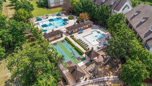 Zona residencial con varios edificios, piscina, canchas de tenis y un parque infantil.