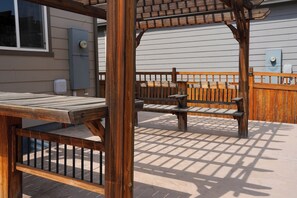 Une terrasse extérieure en bois, avec un banc et une table.