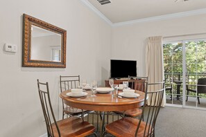 Un comedor con una mesa redonda, sillas y un televisor.