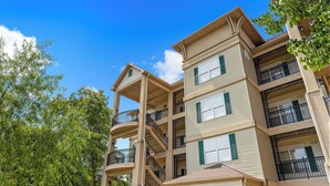 A multi-story residential building with balconies and a central staircase. - French Quarter Resort | Queen Condo | Great Location (Branson)